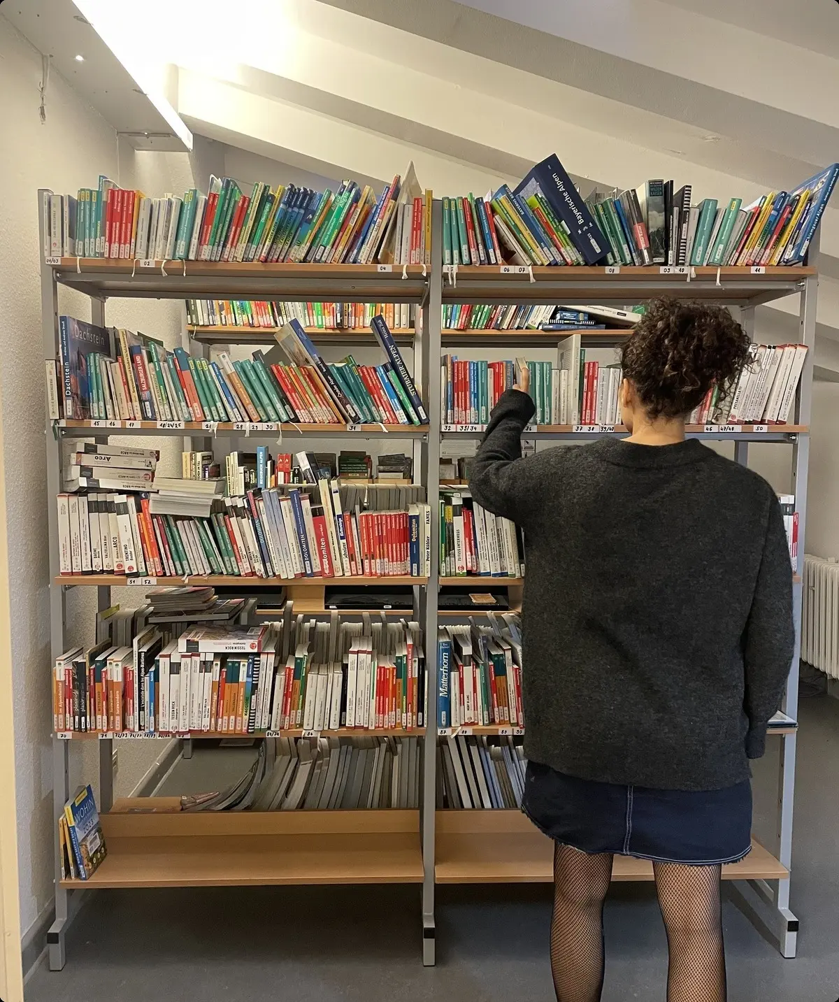 Besucherin stöbert im Regal | © Hannah Paranaitis
