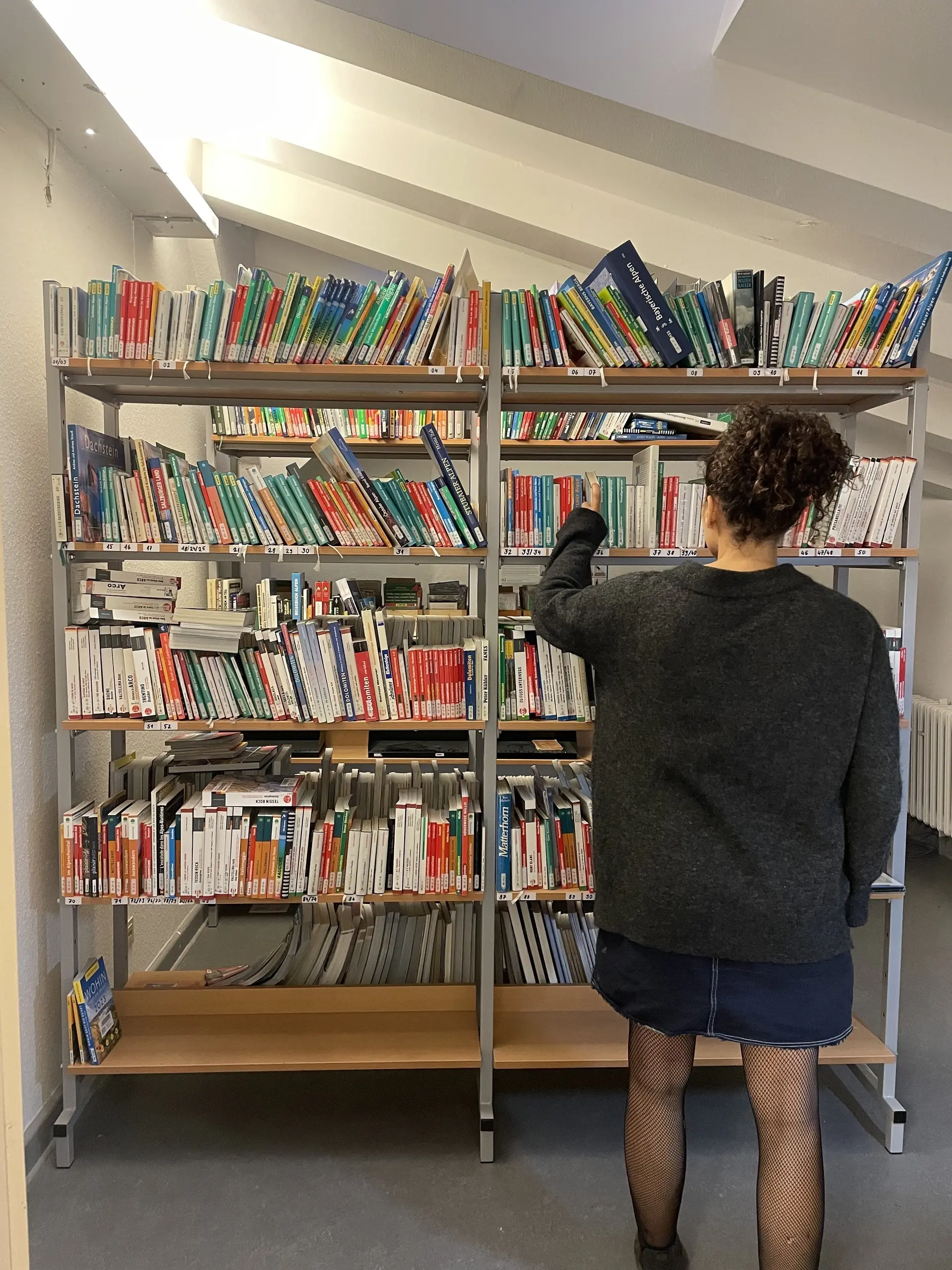 Besucherin stöbert im Regal | © Hannah Paranaitis